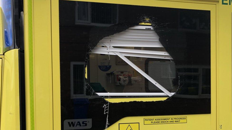 A smashed side window on one of the ambulances