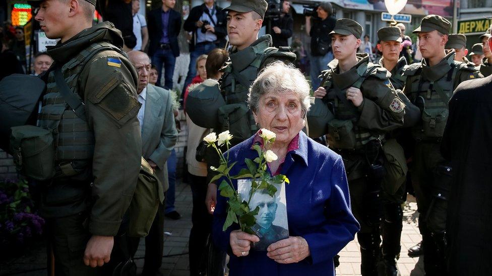 A woman carries a picture of a World War Two participant as she takes part in the Immortal Regiment march during the Victory Day celebrations, marking the 71st anniversary of the victory over Nazi Germany in World War Two, in central Kiev, Ukraine, May 9, 2016.