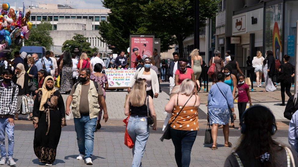 Shoppers in Birmingham city centre, some with and some without face coverings.