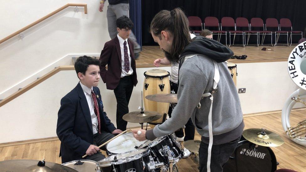 boys being taught to drum