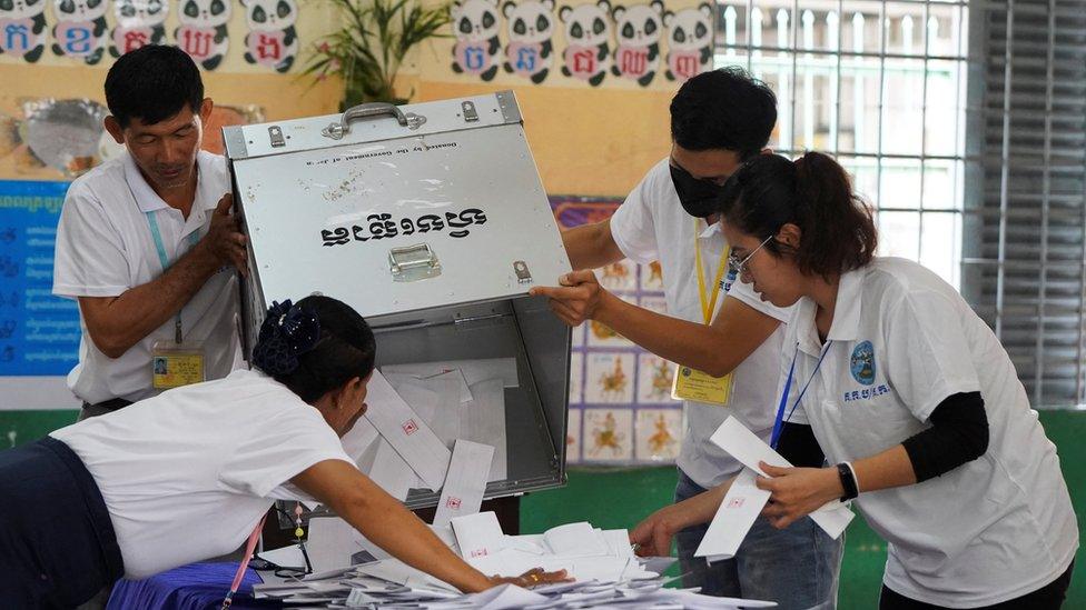 Election officials count ballots at a polling station on the day of Cambodia's general election