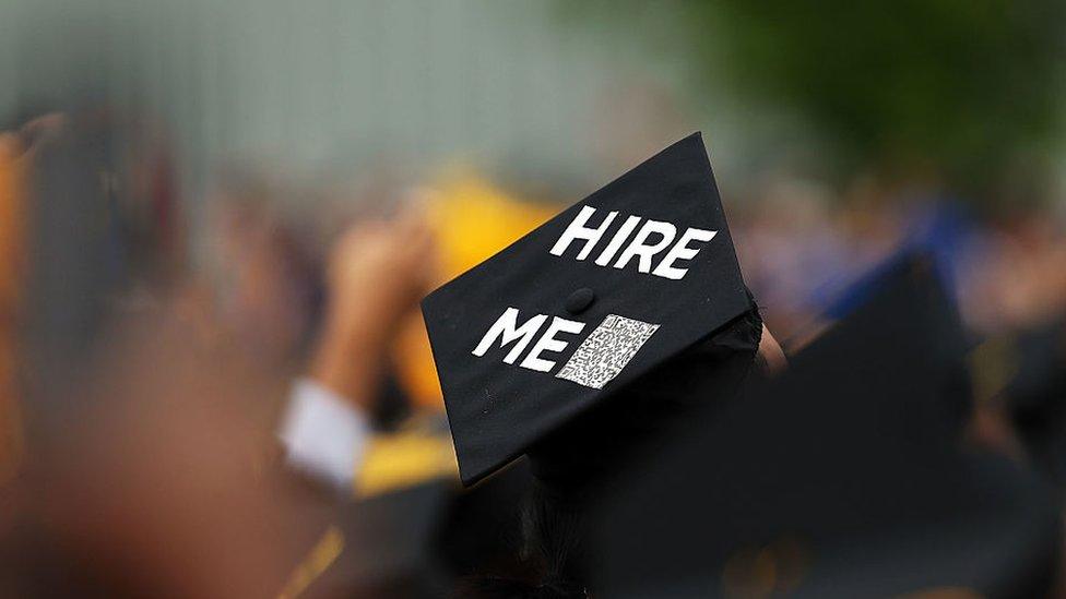 Graduate with sign on hat