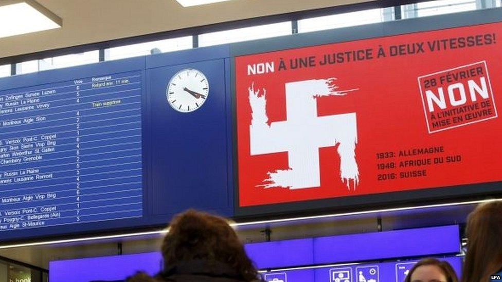 Campaign advert shows montage of the white cross of the Swiss national flag and the Swastika symbol, at a Geneva train station 23/02/2016