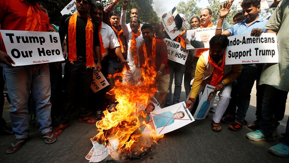 Members of Hindu Sena, a right-wing Hindu group, burn posters of Hillary Clinton during a rally in support of Donald Trump in New Delhi, India - 18 October 2016