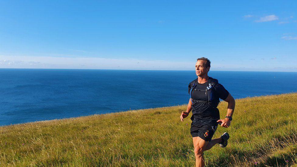 Paul Minter running by the sea