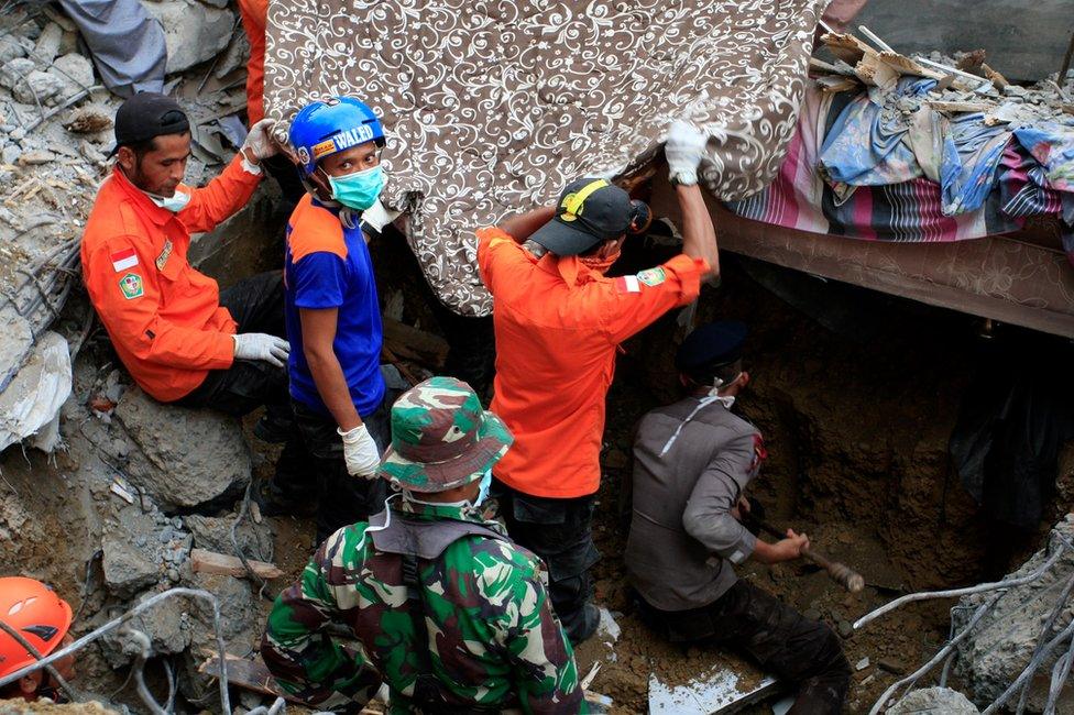 Indonesian army and the Search and Rescue Team look for survivors amongst the rubble on 7 December 2016 in Lueng Putu town, Aceh Province, Indonesia.