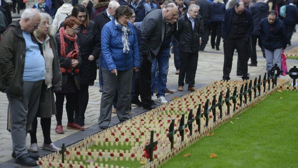 People look at crosses in the the Garden of Remembrance at Belfast City Hall