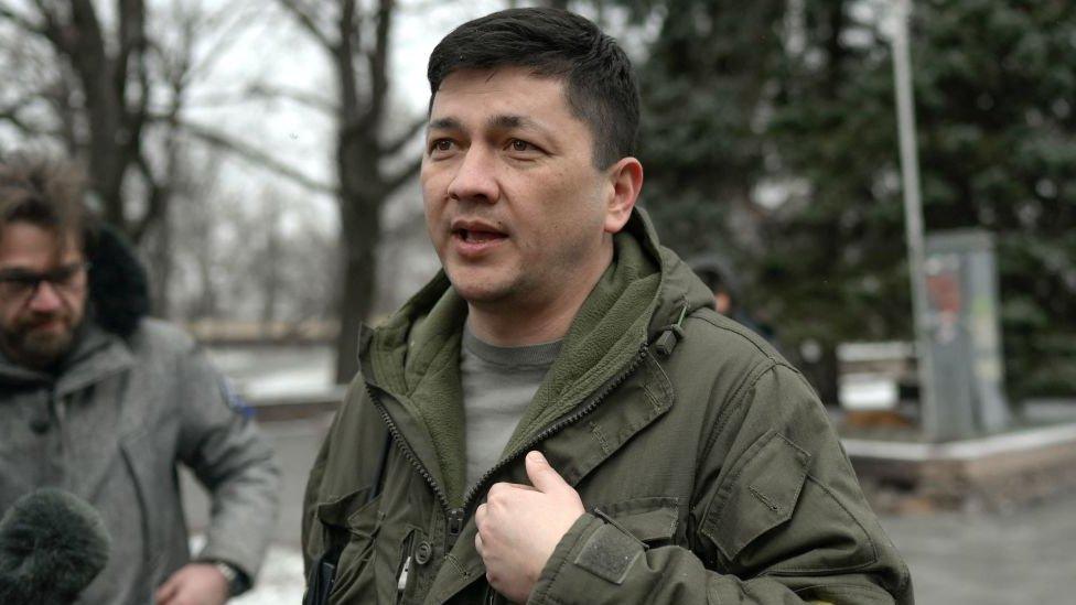 Image shows Vitaly Kim standing speaking to a camera