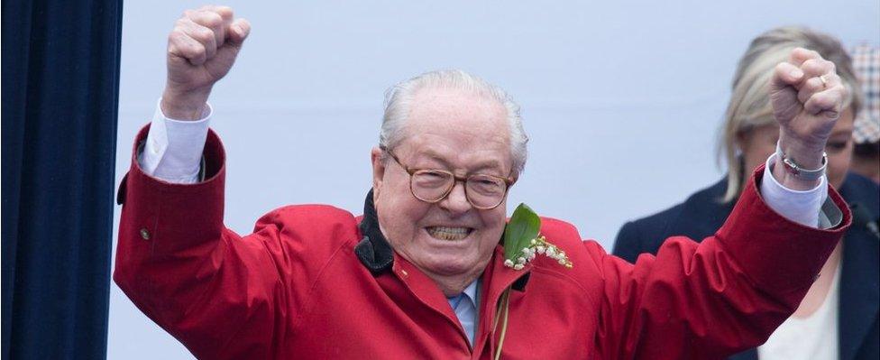 France's far-right political party Front National (FN) founder and honorary president, Jean-Marie Le Pen gestures on stage as FN's president Marine Le Pen looks on during the party's annual rally honouring Joan of Arc on Place de l'Opera, on 1 May 2015 in Paris, France.