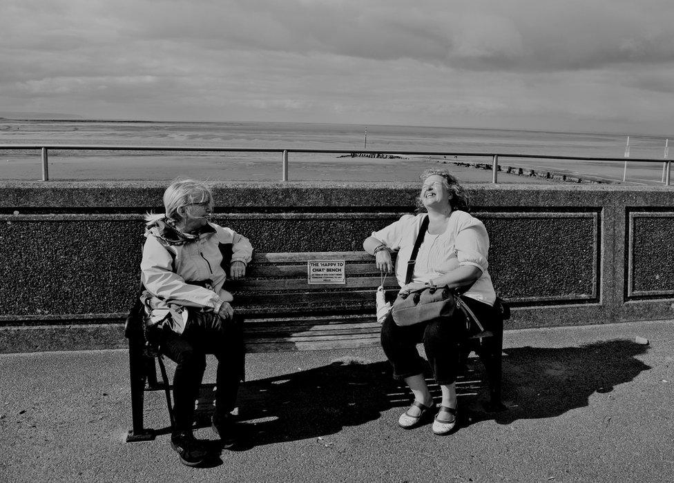 Two women talking on a bench