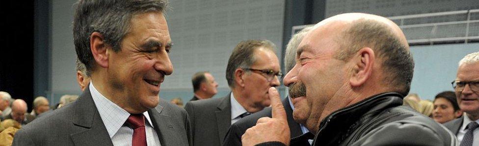 Republicans contender in the primaries ex-French Prime Minister Francois Fillon (L) speaks with an activist during a public meeting on 4 November 2016 in Saint-Brieuc, western France.