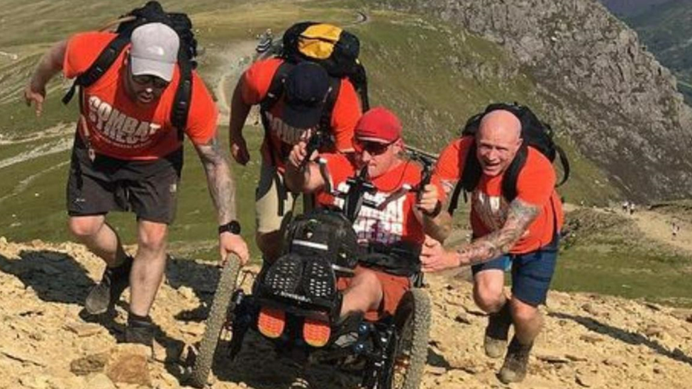 Four men hiking up a hill