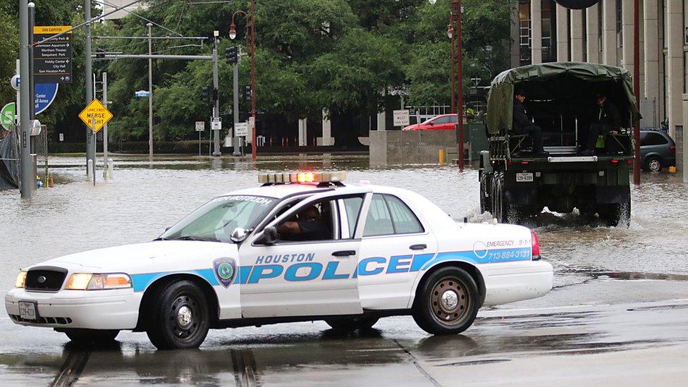 Image shows a Houston Police vehicle in flood waters.