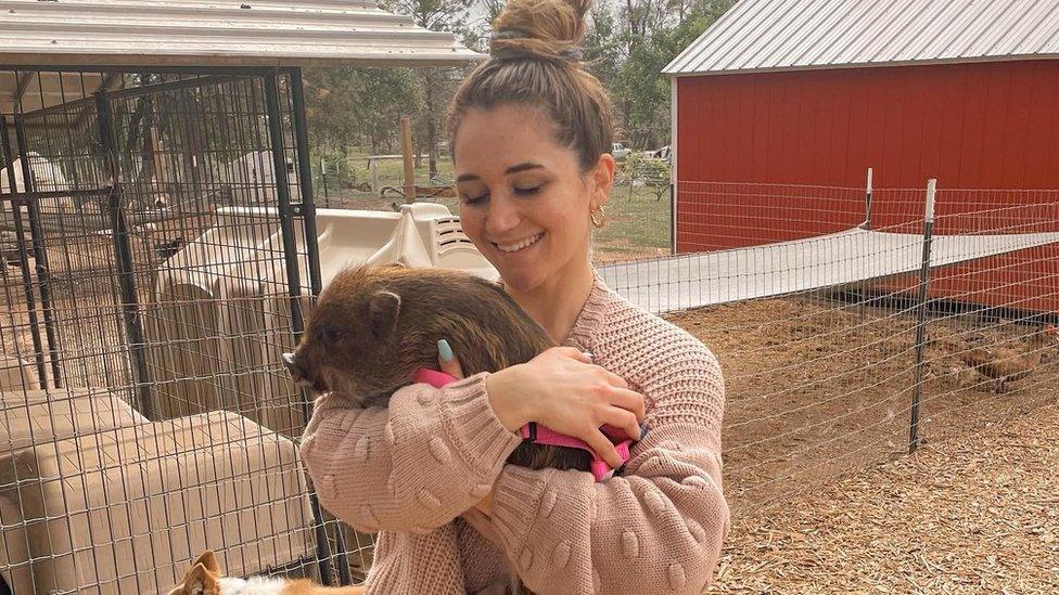 Mina holding Merlin the pig