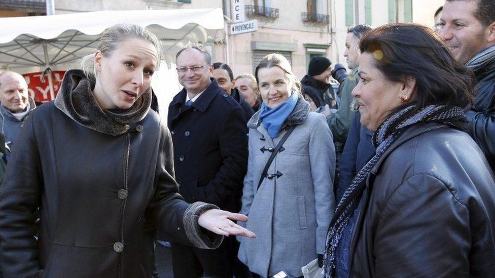 Marion Marechal-Le Pen, left, argues with a woman as she campaigns at the Saint-Siffrein fair in Carpentras