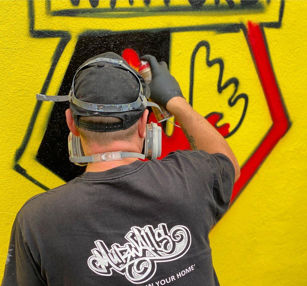 Street artist painting a mural