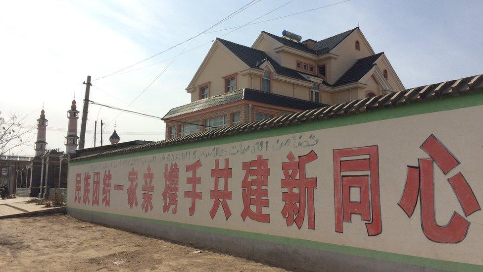 A propaganda slogan in Chinese and Arabic in Weizhou. It reads, 'A unified national family joins hands to build a new Tongxin County'