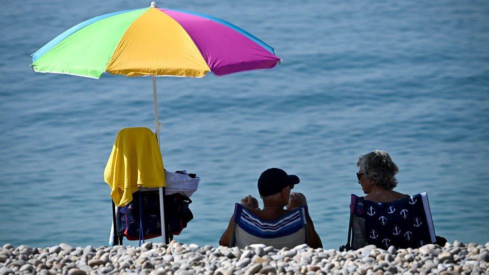 People in the shade on Brighton Beach