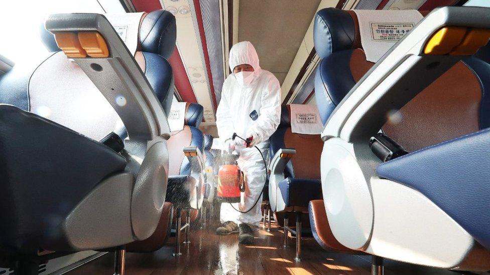 Worker disinfecting a train