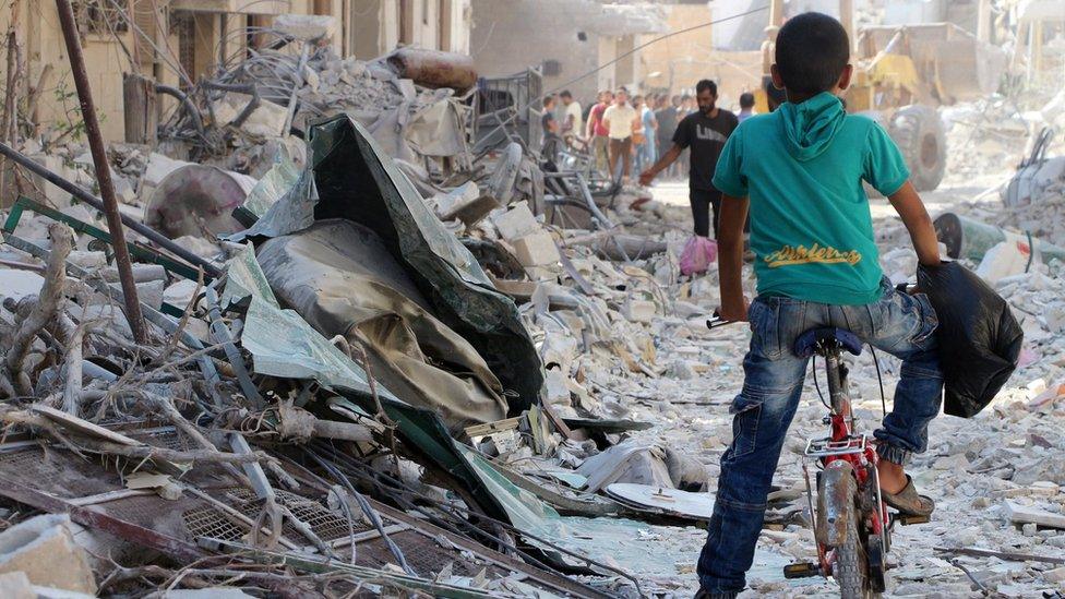 People search for survivors in the rubble after an air strike in Armanaz, Idlib province, Syria (30 September 2017)