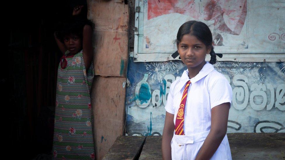 Malki standing in front of her home