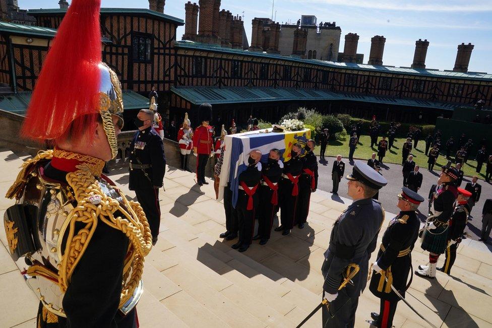 The Duke of Edinburgh's coffin, covered with his Personal Standard, is carried into St George's Chapel, Windsor Castle, Berkshire, ahead of the funeral of the Duke of Edinburgh. April 17, 2021.