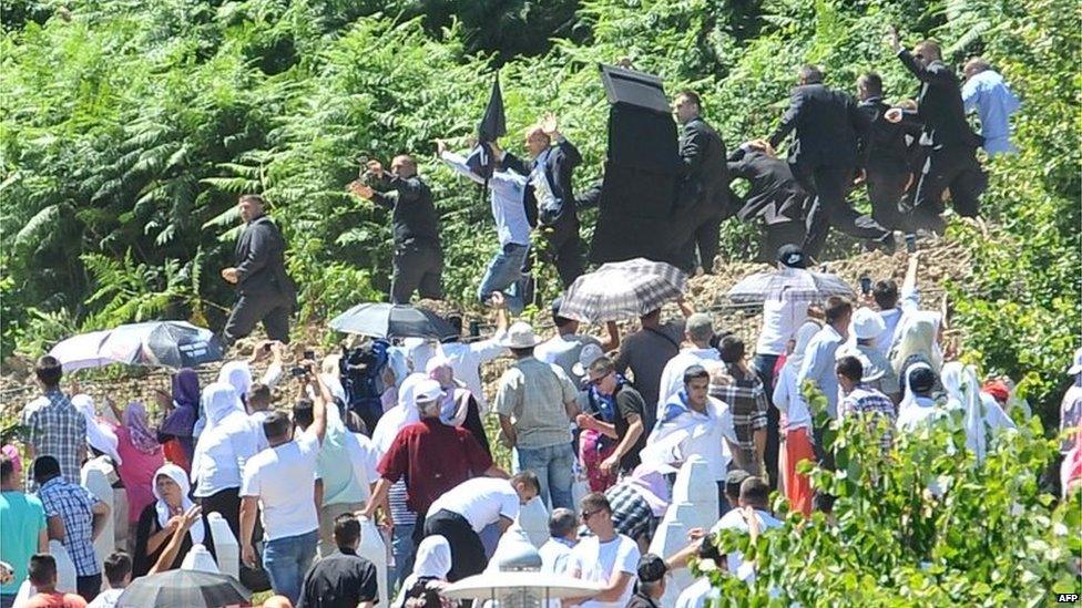 Serbian Prime Minister Aleksandar Vucic and his delegation, escorted by security forces, leave the Potocari Memorial Cemetery