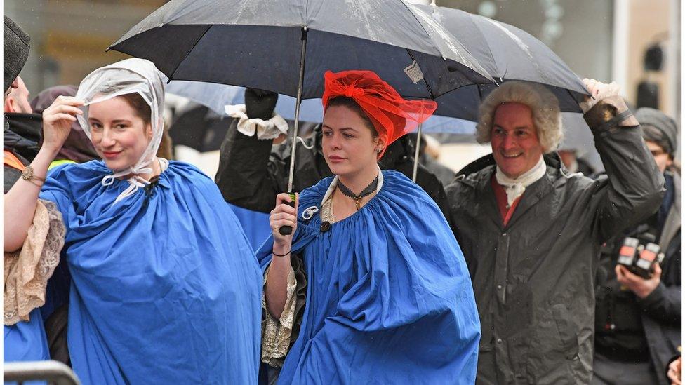 cast members stay dry in the rain