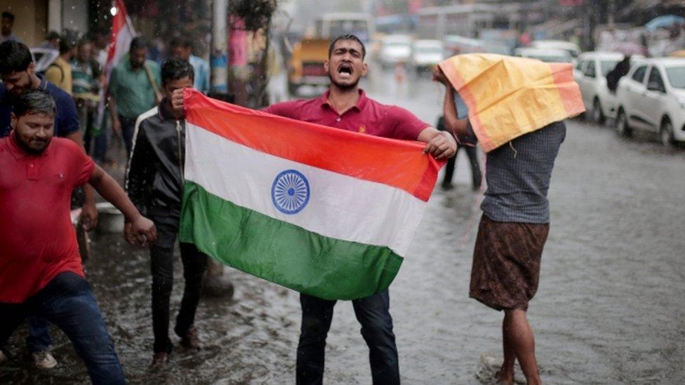 An Indian man holds up an Indian flag in celebration after Indian said it targeted militants in Pakistan