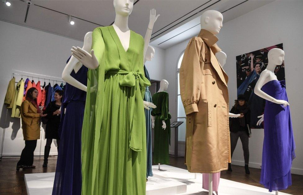 Visitors chat at the Christie's auction house in Paris during a presentation of Catherine Deneuve's YSL clothes