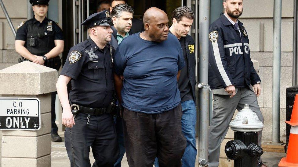 Frank James is escorted out by officers after his arrest in Brooklyn