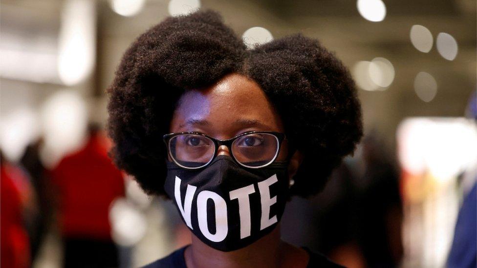 Ashley Nealy waits in line to cast her ballot during early voting for the upcoming presidential elections