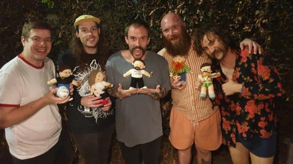 Idles holding their mini-me dolls