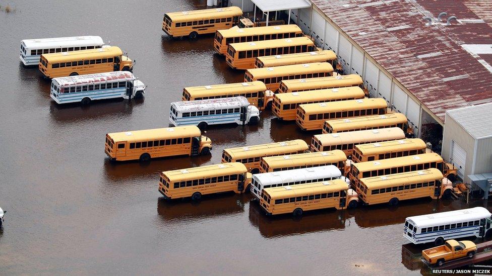 Several yellow school buses in floodwaters