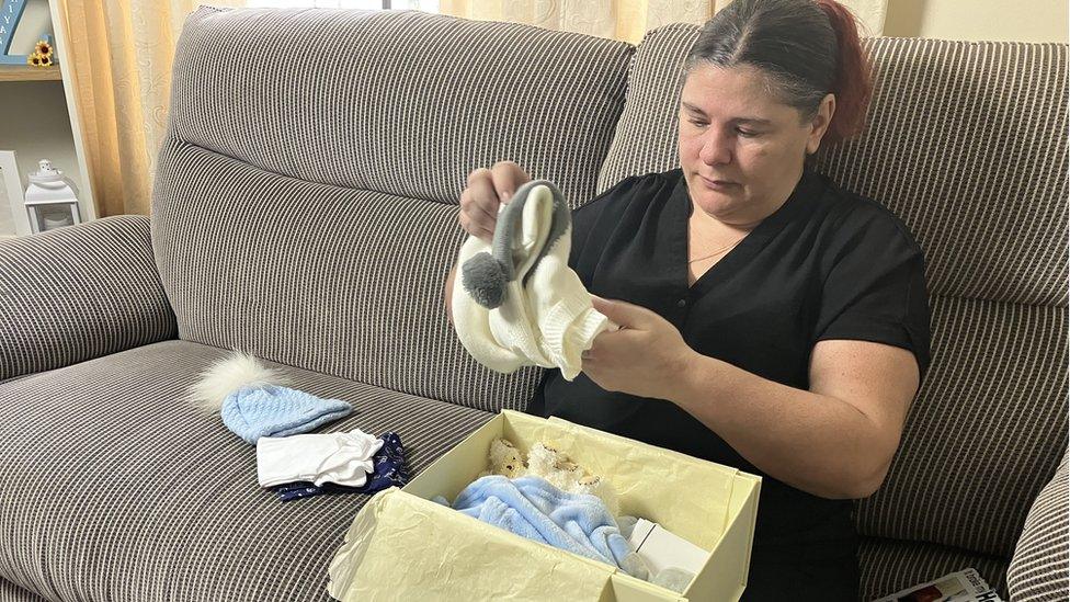 Hayley Ryan hold a box of baby clothes