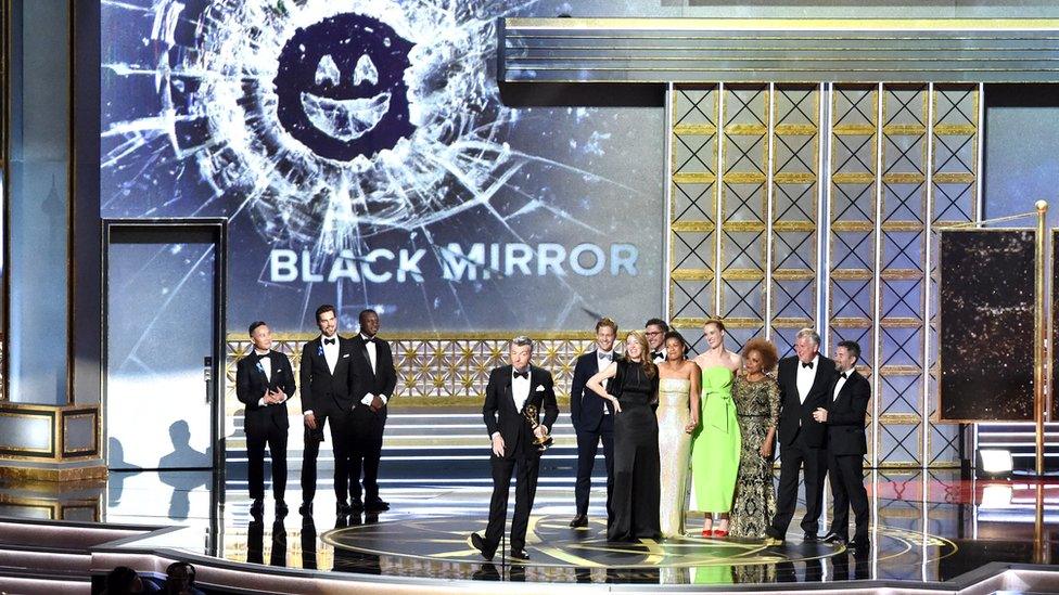 An image of the Black Mirror cast receiving an Emmy award