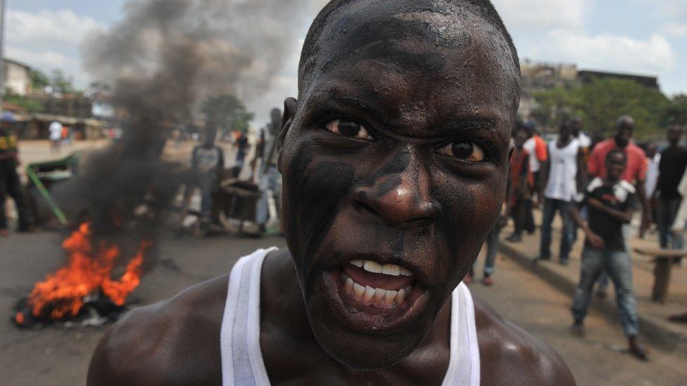 Protestiwr yn ninas Abidjan yn dilyn etholiadau dadleuol Y Traeth Ifori yn 2010