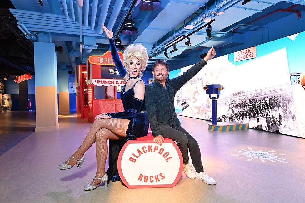 Funny Girls performer Lady CeCe D'Vyne and owner Basil Newby sitting on a bench in the style of Blackpool Rock in Showtime museum