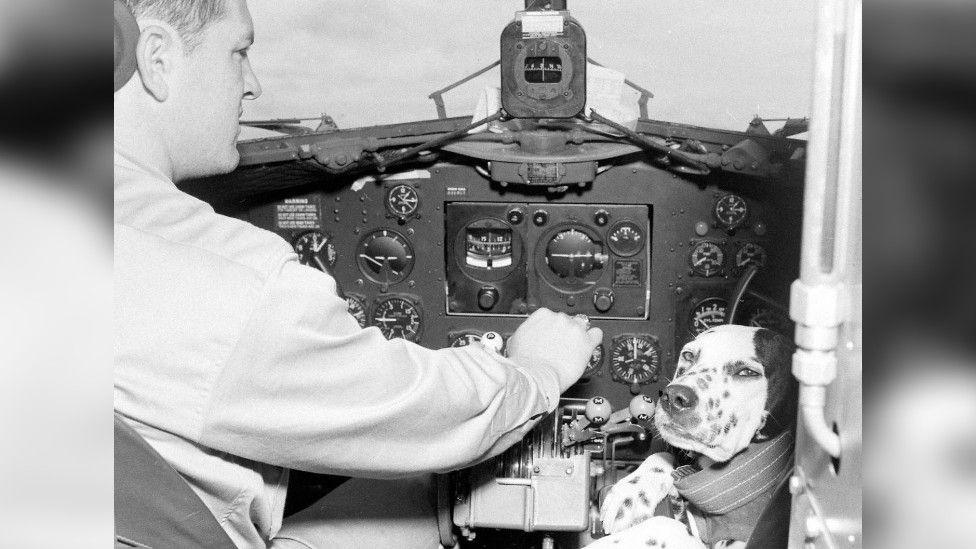 Black and white photograph of Lt Col Frederick at the controls of the aircraft with Major Jerry sat by his side.