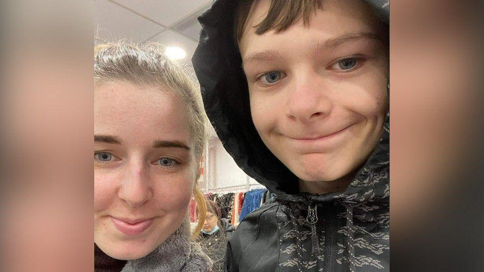 Brother and sister Chloe and Mason take a selfie in a clothes shop.