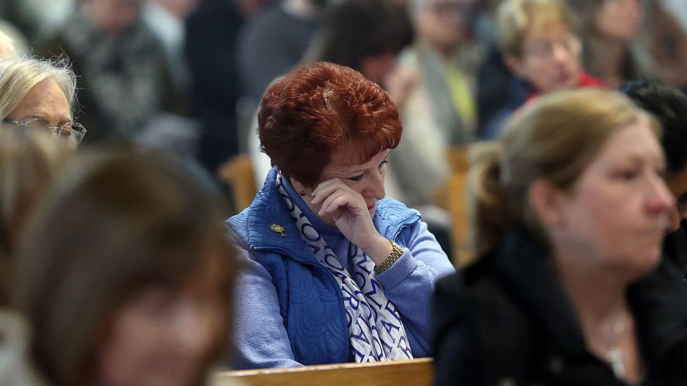 A mourner wipes away a tear at a special mass at St Andrew's Cathedral in Glasgow after the announcement of the death of Pope Francis