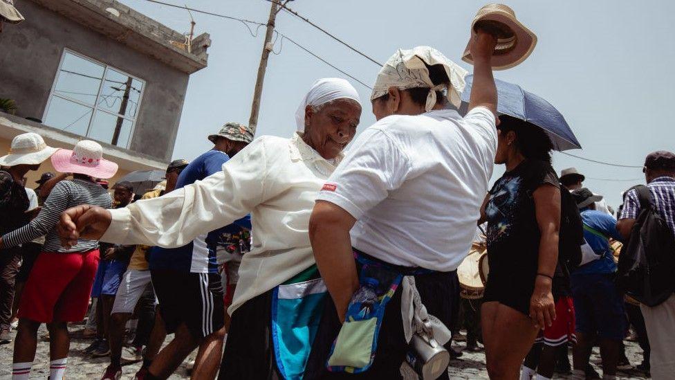 Two women dance during the pilgrimage in Porto Novo