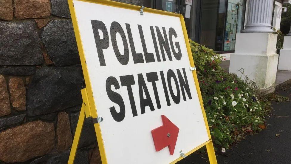 A sign with the words polling station outside the Vale Douzaine Room