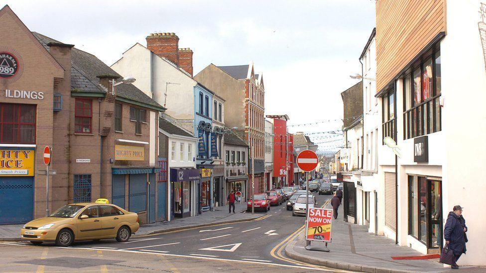 A wide short of Strabane town centre, cars can be seen as well as pedestrians