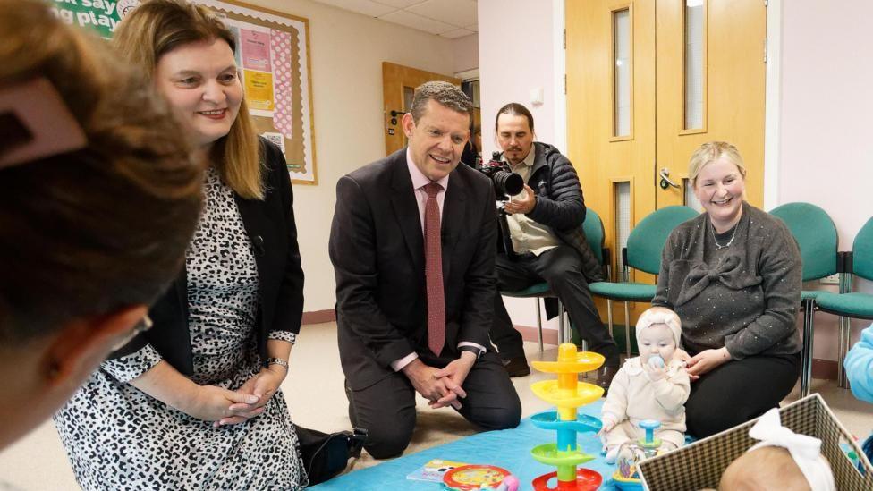 Mae'r llun yn dangos Rhun ap Iorwerth a'i ddirprwy Sioned Williams yn cyfarfod â mamau a'u plant mewn meithrinfa.