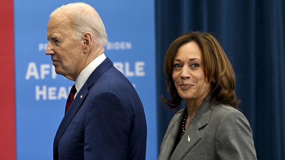 Joe Biden and Kamala Harris walk in front of campaign promotion materials in North Carolina in March