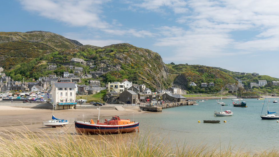 A seaside view of Barmouth with houses and boats