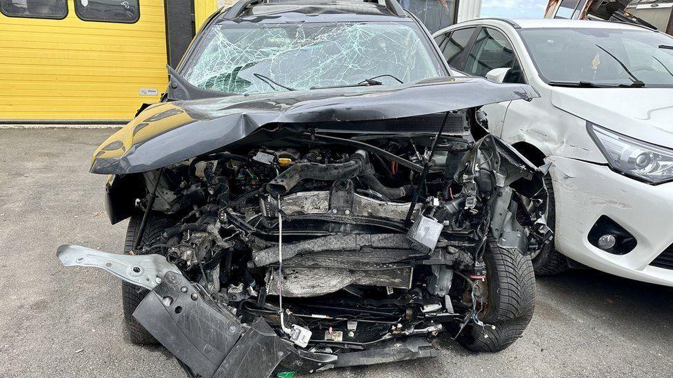 Damaged hire car showing front of car wrecked and windscreen smashed