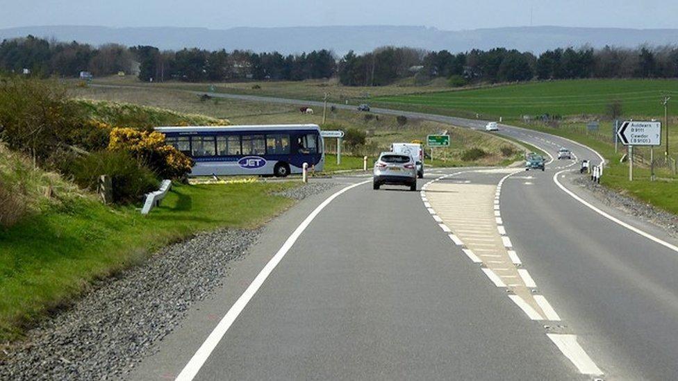 Bus a' feitheamh tighinn air an A96 aig Allt Èireann, faisg air Inbhir Narann