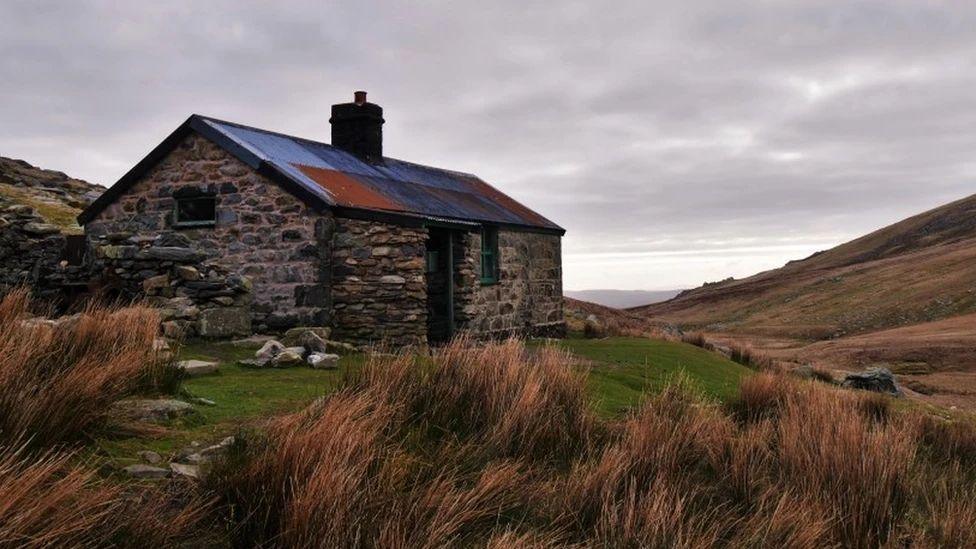 Am antur hynod wyllt mae bwthyn Dulyn yn cynnig cysgod ar lethrau'r Carneddau. Mae'r adeilad yma yn dyddio 'nôl i 1880 pan adeiladwyd argae cyfagos


